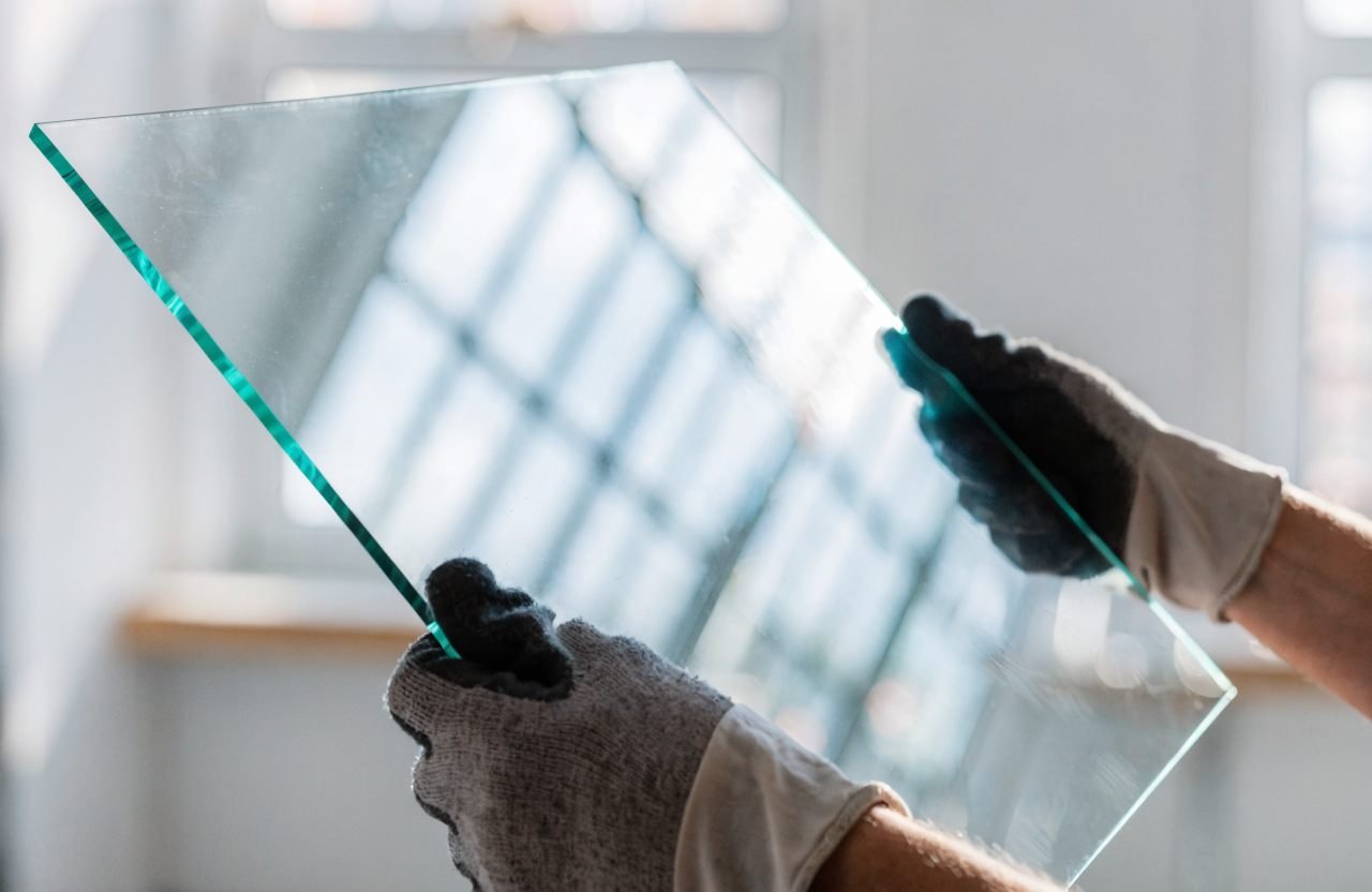 Glazier carrying a cut-to-size glass sheet in our London workshop