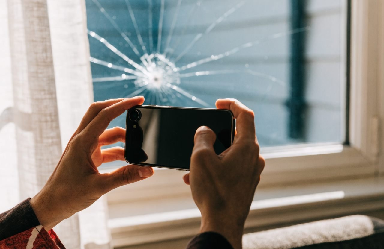 Customer photographing a cracked window to WhatsApp for a free glazing quote